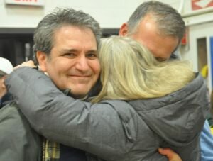 Democratic campaign manager Barbara Reynolds embraces Chris Spaulding and Brian Gordon after the election results were announced. — Gregory Menti photo